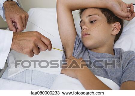 Stock Image - Doctor taking boy's temperature with thermometer, cropped. Fotosearch