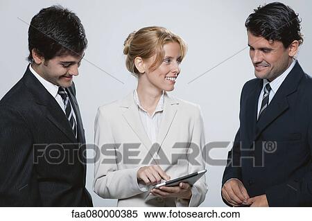 Stock Photography - Executives looking at digital tablet together. Fotosearch