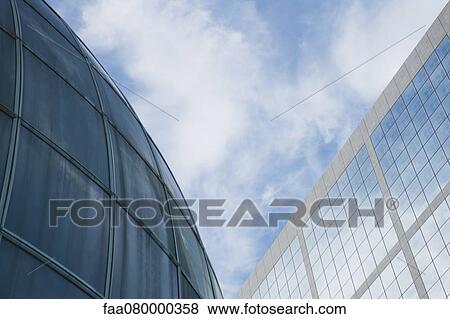 Stock Photo - Facade of high rises against sky, low angle view. Fotosearch