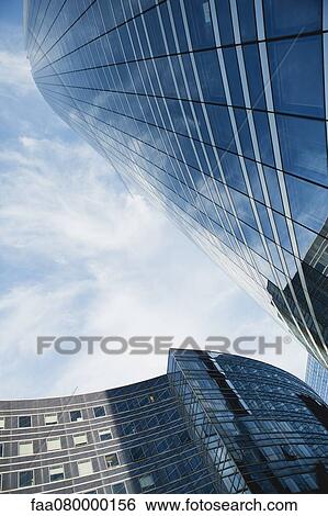 Facade of modern buildings against sky, low angle view View Large Photo Image Stock Photograph - Facade of modern buildings against sky, low angle view. Fotosearch