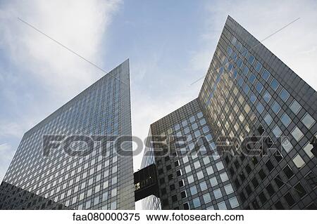 Stock Photography - Facade of modern office buildings against sky, low angle view. Fotosearch