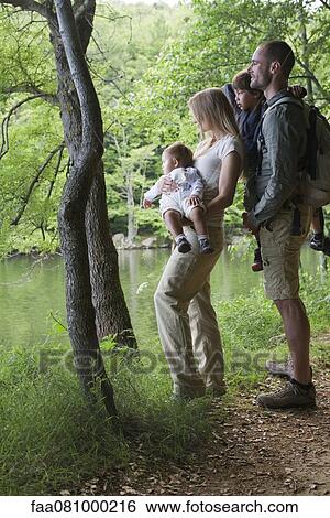 Stock Photograph - Family in woods looking at river. Fotosearch