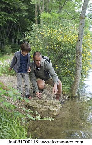 Stock Photograph - Father and son by river. Fotosearch