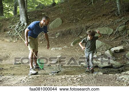 Father and son in woods, boy jumping over stream View Large Photo Image Picture - Father and son in woods, boy jumping over stream. Fotosearch
