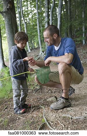 Stock Image - Father and son in woods. Fotosearch