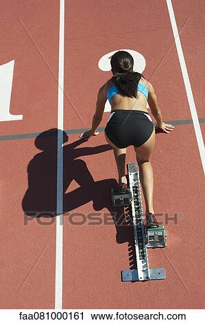 Female athlete in starting position on running track, rear view View Large Photo Image Stock Image - Female athlete in starting position on running track, rear view. Fotosearch