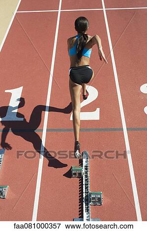 Female athlete leaving starting line, rear view View Large Photo Image Stock Photo - Female athlete leaving starting line, rear view. Fotosearch