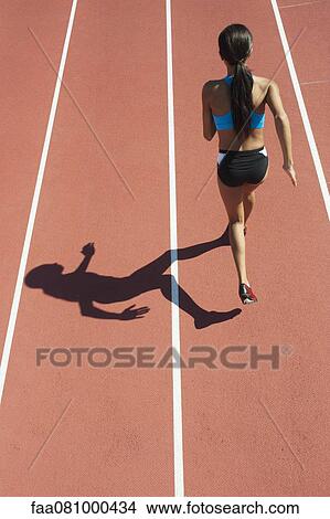 Female athlete running on track, rear view View Large Photo Image Picture - Female athlete running on track, rear view. Fotosearch