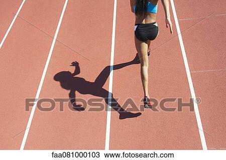 Female athlete running on track, rear view View Large Photo Image Stock Image - Female athlete running on track, rear view. Fotosearch