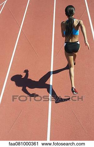 Stock Image - Female athlete running on track, rear view. Fotosearch