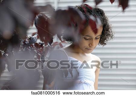 Girl behind leafy branches, looking down View Large Photo Image Stock Photograph - Girl behind leafy branches, looking down. Fotosearch