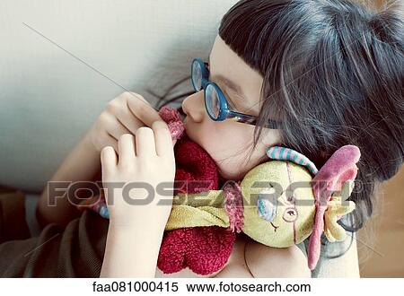 Stock Photography - Girl cuddling stuffed toy. Fotosearch