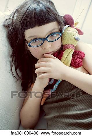 Stock Photo - Girl holding stuffed toy, portrait. Fotosearch