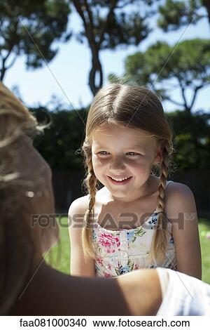 Stock Image - Girl outdoors, smiling. Fotosearch