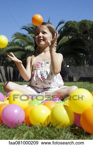 Stock Photo - Girl playing with plastic balls. Fotosearch