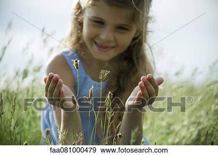 Girl staring at butterfly on wildflower View Large Photo Image Stock Photo - Girl staring at butterfly on wildflower. Fotosearch