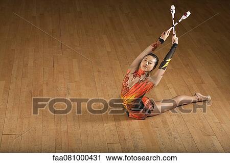 Gymnast bending backwards, holding clubs View Large Photo Image Stock Image - Gymnast bending backwards, holding clubs. Fotosearch
