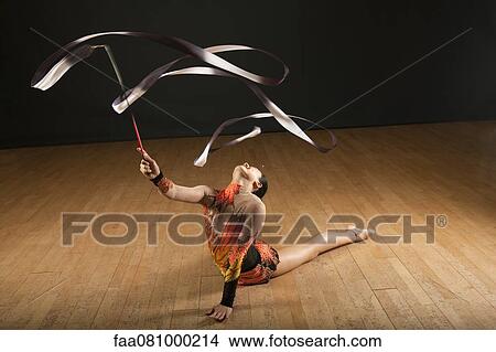 Gymnast bending backwards on floor, twirling ribbon View Large Photo Image Picture - Gymnast bending backwards on floor, twirling ribbon. Fotosearch
