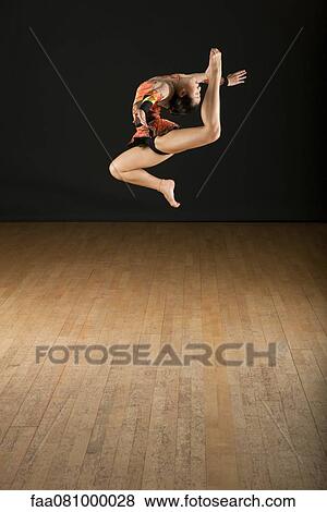 Stock Photo - Gymnast jumping in air. Fotosearch