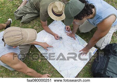 Hikers using compass and looking at map together, high angle view View Large Photo Image Stock Image - Hikers using compass and looking at map together, high angle view. Fotosearch
