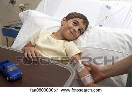 Hospitalized by being comforted by out-of-frame adult View Large Photo Image Stock Photo - Hospitalized by being comforted by out-of-frame adult. Fotosearch