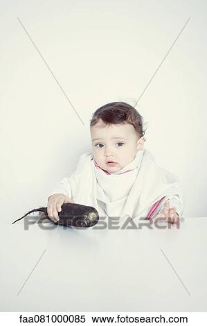 Stock Photography - Infant and root vegetable, portrait. Fotosearch