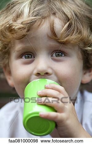 Stock Photo - Little boy drinking from cup, portrait. Fotosearch