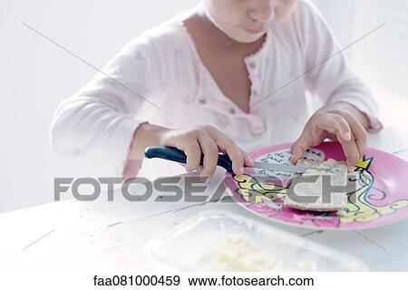 Stock Photo - Little girl preparing a snack, cropped. Fotosearch