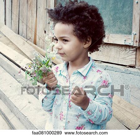 Little girl smelling flowers View Large Photo Image Stock Photo - Little girl smelling flowers. Fotosearch