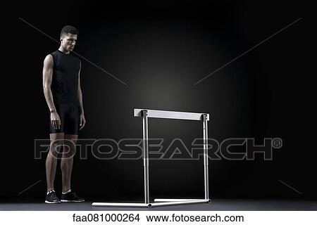 Male athlete standing behind hurdle View Large Photo Image Picture - Male athlete standing behind hurdle. Fotosearch
