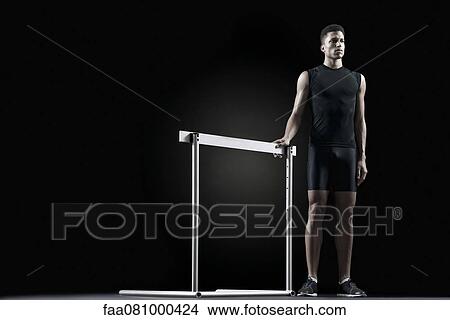 Male athlete standing by hurdle View Large Photo Image Picture - Male athlete standing by hurdle. Fotosearch