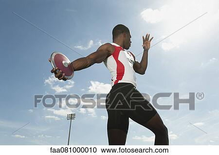 Male athlete throwing discus, low angle view View Large Photo Image Stock Image - Male athlete throwing discus, low angle view. Fotosearch