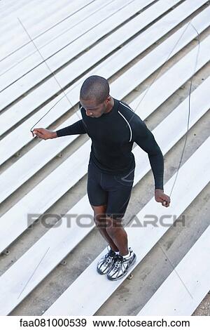 Man jumping rope on bleacher, high angle view View Large Photo Image Stock Photo - Man jumping rope on bleacher, high angle view. Fotosearch