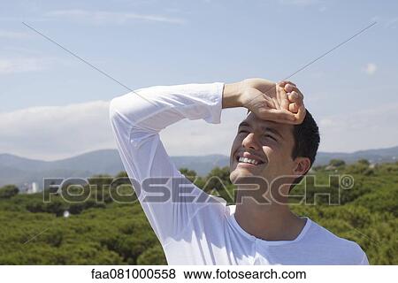 Man shading eyes from sun View Large Photo Image Stock Photo - Man shading eyes from sun. Fotosearch