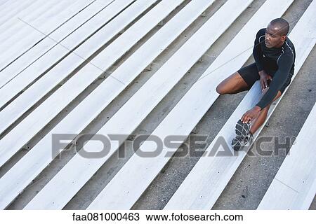 Man stretching on bleacher, high angle view View Large Photo Image Stock Image - Man stretching on bleacher, high angle view. Fotosearch