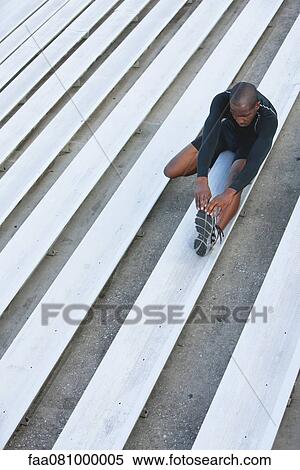 Man stretching on bleacher, high angle view View Large Photo Image Stock Photography - Man stretching on bleacher, high angle view. Fotosearch