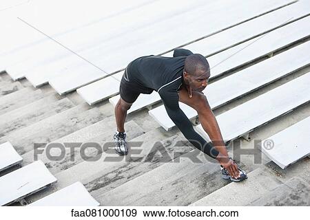 Man stretching on bleacher steps View Large Photo Image Stock Photo - Man stretching on bleacher steps. Fotosearch