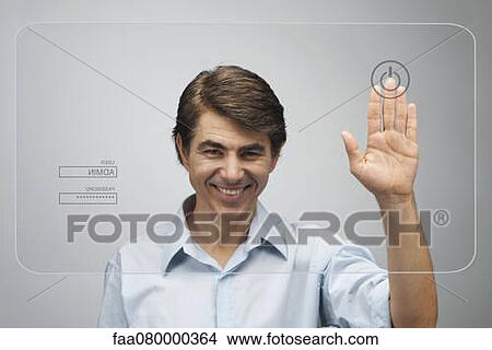 Picture - Man touching power button on advanced touch screen interface. Fotosearch