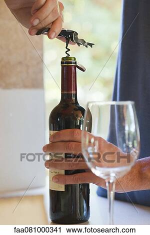Man uncorking bottle of wine, cropped View Large Photo Image Stock Image - Man uncorking bottle of wine, cropped. Fotosearch