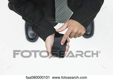 Stock Image - Man using smartphone, cropped, elevated view. Fotosearch