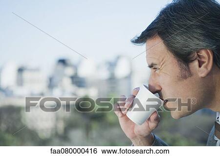Mature businessman drinking from disposable cup, side view View Large Photo Image Stock Photograph - Mature businessman drinking from disposable cup, side view. Fotosearch