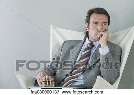 Mature businessman relaxing with drink and cigar View Large Photo Image Stock Photo - Mature businessman relaxing with drink and cigar. Fotosearch