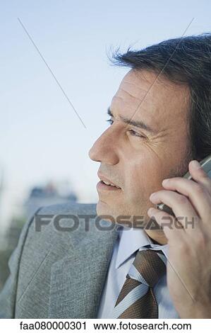 Mature businessman using cell phone, side view View Large Photo Image Stock Image - Mature businessman using cell phone, side view. Fotosearch
