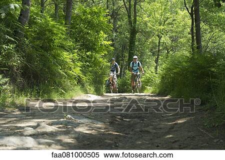 Stock Photography - Men biking in woods. Fotosearch