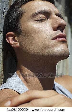 Mid-adult man sunbathing with eyes closed View Large Photo Image Picture - Mid-adult man sunbathing with eyes closed. Fotosearch
