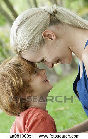 Stock Image - Mother and young son touching foreheads. Fotosearch