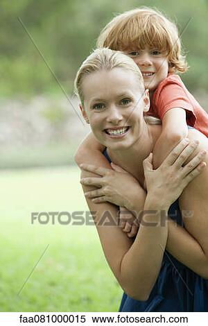 Stock Photography - Mother carrying son on back, portrait. Fotosearch
