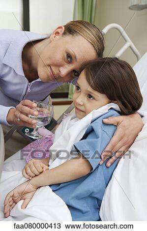 Mother comforting sick daughter in hospital bed View Large Photo Image Stock Image - Mother comforting sick daughter in hospital bed. Fotosearch