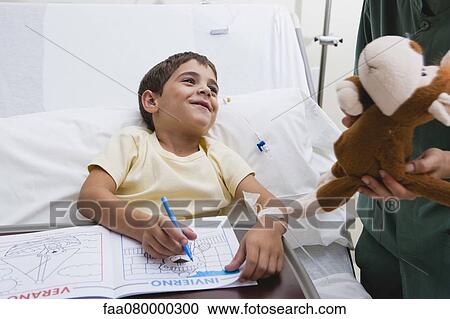 Nurse giving sick boy stuffed animal in hospital, cropped View Large Photo Image Stock Image - Nurse giving sick boy stuffed animal in hospital, cropped. Fotosearch