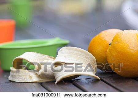 Stock Image - Oranges and half eaten banana. Fotosearch